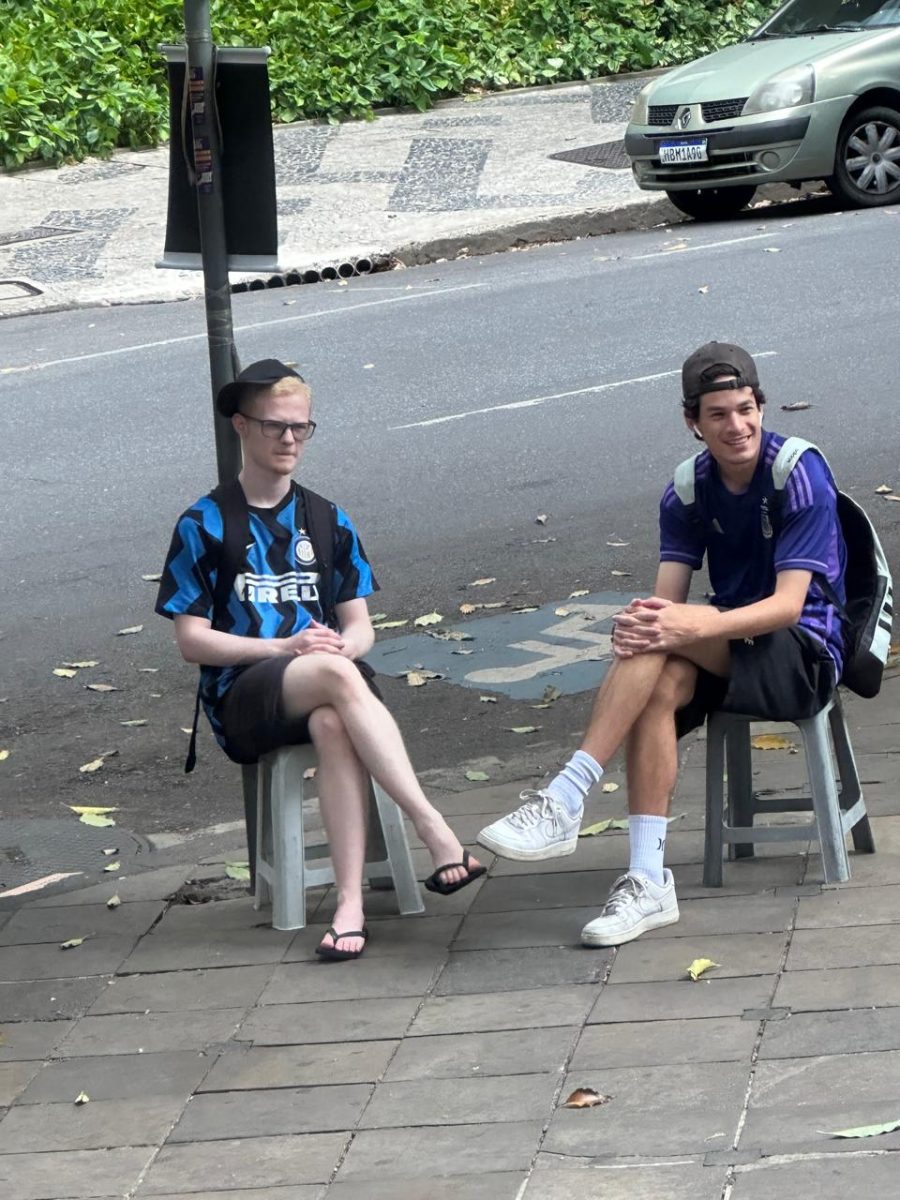 Dois do grupo sentados na calçada